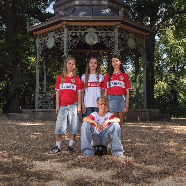 Kinder tragen das neue Kids Auswärtstrikot rot und das Kids Heimtrikot 