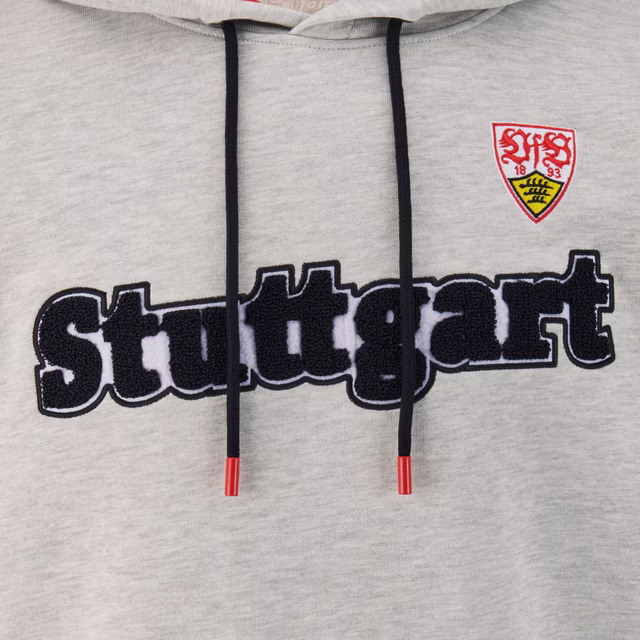 Nahaufnahme des Stuttgart Schriftzugs und des VfB Wappens auf dem Hoodie