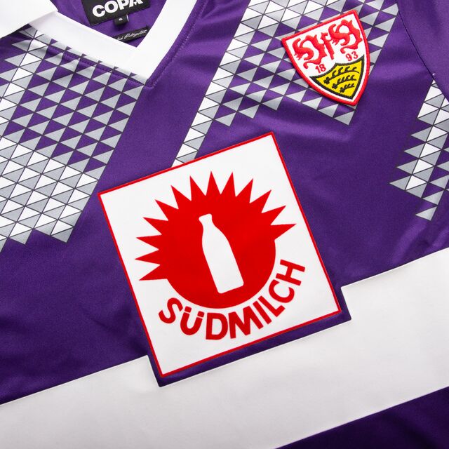 Retro Trikot in lila mit weißem Brustring, Südmilch Logo in der Mitte und weiß-grauen Mustern. Das VfB Wappen befindet sich auf der Brust. Der Hemdkragen ist weiß.