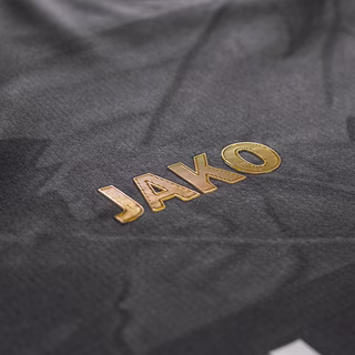 Nahaufnahme des goldenen JAKO Schriftzugs auf dem Auswärtstrikot schwarz 25/26