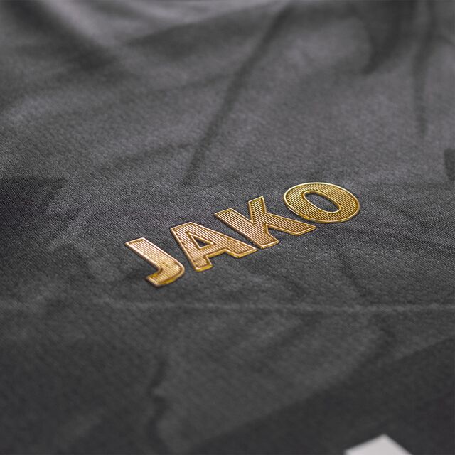 Nahaufnahme des goldenen JAKO Schriftzugs auf dem Auswärtstrikot schwarz 25/26