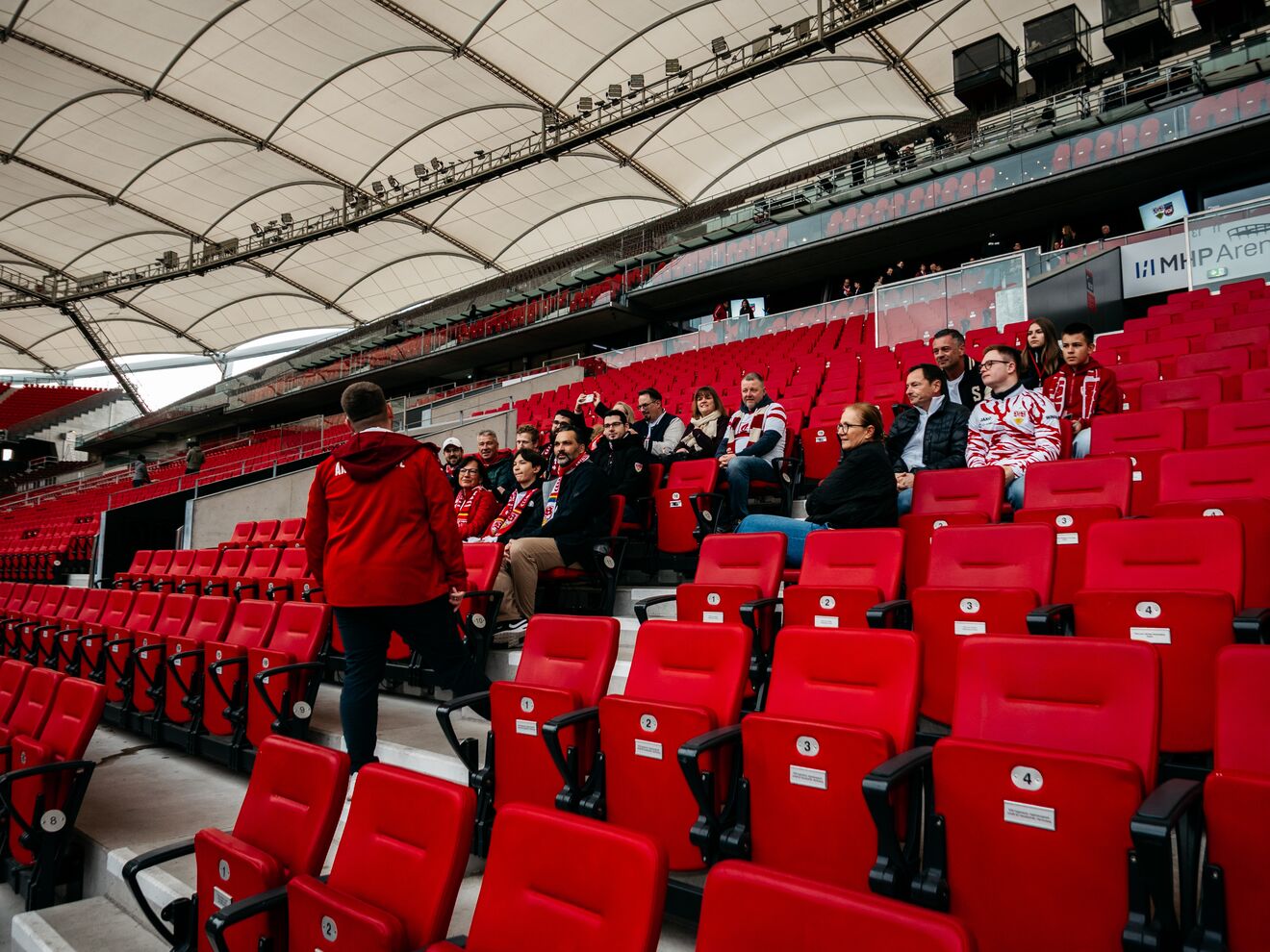 Mehrere Personen sitzen auf der Tribüne 