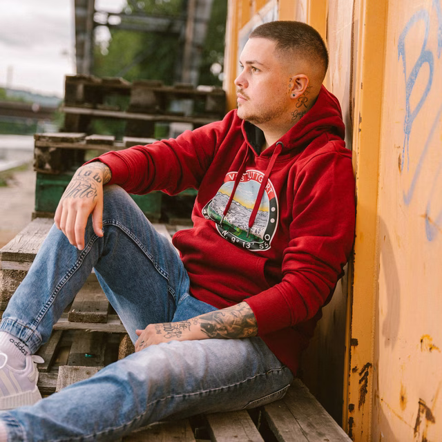 Mann trägt den VfB Hoodie Tradition rot