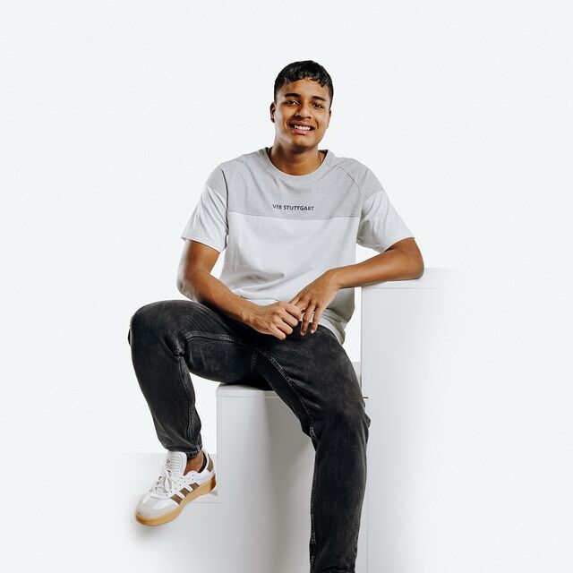 T-Shirt in weiß und grau mit kleinem VfB Stuttgart Schriftzug, getragen von Jeremy Arevalo 