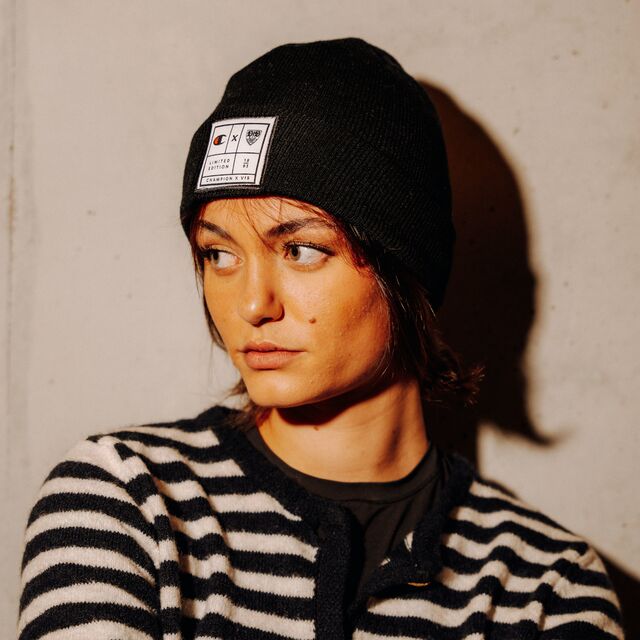 weibliches Model trägt die Champion x VfB Beanie in Schwarz und schaut zur Seite