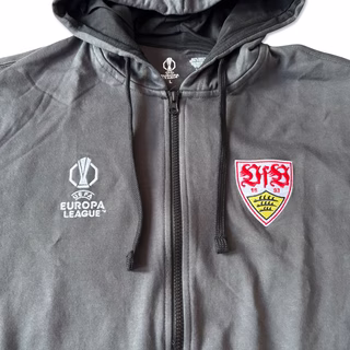Nahaufnahme des VfB Wappens und des Europa League Wappens auf dem Hoodie