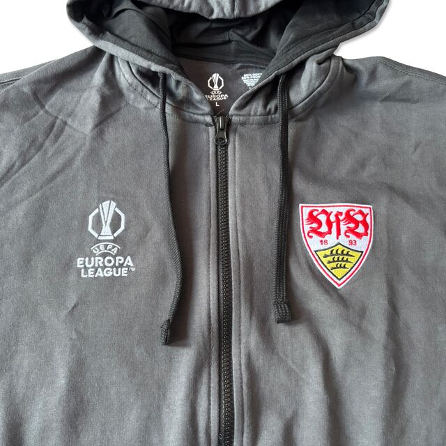 Nahaufnahme des VfB Wappens und des Europa League Wappens auf dem Hoodie