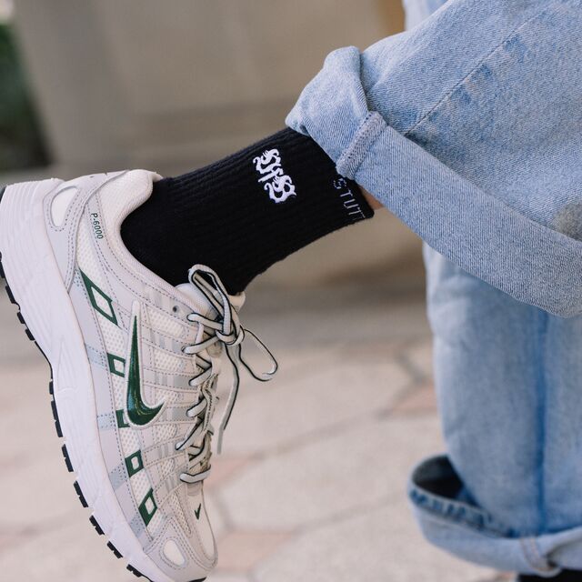 Person trägt VfB Kleinigkeit Socken Wappen in Schwarz und weiße Nike Schuhe