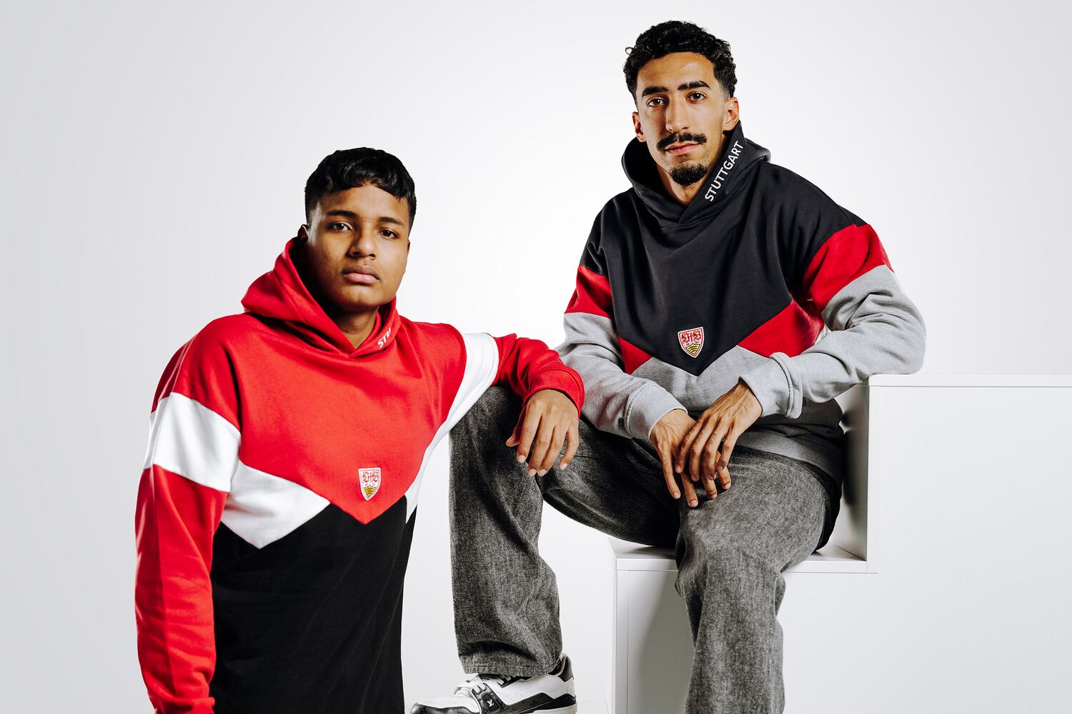 zwei Personen tragen Hoodies der VfB Wappen Kollektion