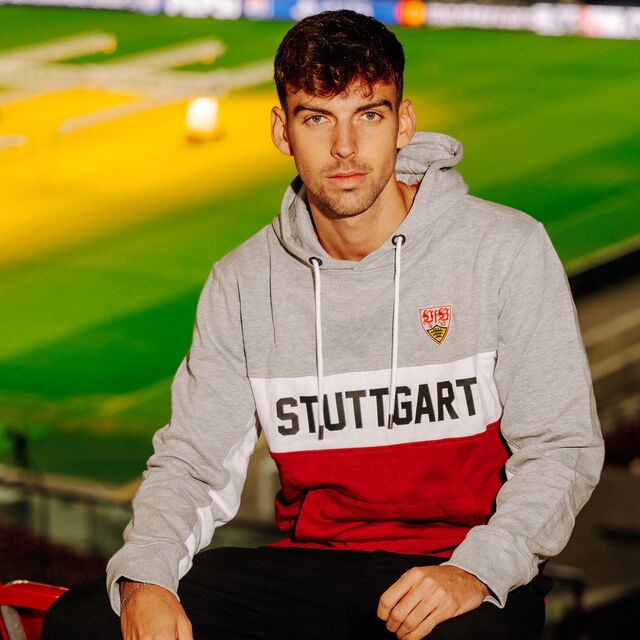 männliches Model trägt den VfB Hoodie Stuttgart in den Farben Grau, Rot und Weiß